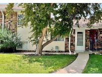 Charming exterior of home featuring a well-manicured lawn and large tree, in a residential neighborhood at 1005 S Miller Way, Lakewood, CO 80226