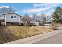 Charming split-level home featuring a manicured front yard, attached garage, and classic brick accents at 412 Gemini Ct, Lone Tree, CO 80124
