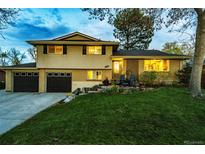 Charming two-story home with a well-manicured lawn, mature tree, and a two car garage at 1140 S Dover St, Lakewood, CO 80232