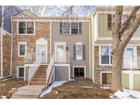 Charming townhome exterior featuring stone accents, a small front porch, and inviting steps to the entrance at 10188 W Dartmouth Ave, Lakewood, CO 80227