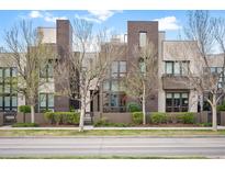 Modern townhome with a well-manicured lawn and contemporary architectural details at 8071 E 29Th Ave, Denver, CO 80238