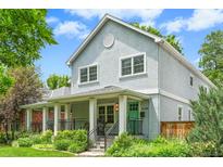 Inviting two-story home featuring a charming front porch with a vibrant turquoise-colored front door at 2485 S Fillmore St, Denver, CO 80210