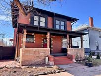 Charming two-story home with a brick facade, inviting porch, and well-maintained landscaping, offering timeless appeal at 114 E 2Nd Ave, Denver, CO 80203