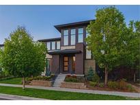 Modern two-story home featuring a manicured lawn, tasteful landscaping, and a stylish brick facade at 8565 E 50Th Dr, Denver, CO 80238