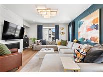 Bright living room boasts hardwood floors, large sectional sofa, modern fireplace, and stylish decor at 15020 Cast Pebble Cir, Parker, CO 80134