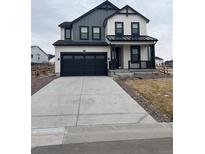 Charming two-story home featuring a covered porch, a two-car garage and modern black and white color scheme at 1041 W Witherspoon Dr, Elizabeth, CO 80107