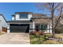Charming two-story home featuring a well-manicured lawn, black trim, a black garage door, and a concrete driveway at 4969 Thorndike Ave, Castle Rock, CO 80104