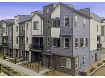 Modern townhome featuring a stylish multi-tone exterior and well-maintained landscaping at 12283 W 57Th Ln, Arvada, CO 80002