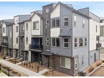Modern townhouse exterior with gray siding, brick accents, and black trim details at 12283 W 57Th Ln, Arvada, CO 80002