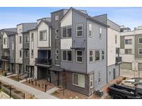 Modern townhome features a stylish gray exterior with a private balcony and well-maintained landscaping at 12283 W 57Th Ln, Arvada, CO 80002