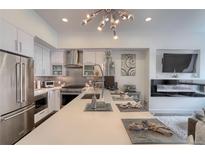 Modern kitchen featuring stainless steel appliances, sleek white cabinetry, and a stylish lighting fixture at 3030 Wilson Ct # 5, Denver, CO 80205