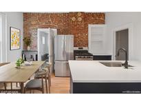 Charming kitchen with stainless steel appliances, a dining area, and exposed brick accents at 3817 Osage St, Denver, CO 80211