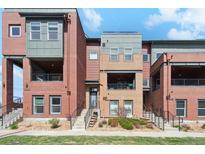 Modern townhome complex with brick and siding exteriors, balconies, and well-maintained landscaping on a sunny day at 5471 W 97Th Pl # E, Broomfield, CO 80020