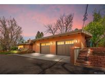Charming brick home featuring a spacious two-car garage, complemented by an inviting landscape and stairway at 5471 S Sherman St, Littleton, CO 80121