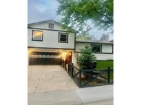 Charming two-story home with a black garage door and well-maintained front yard at 1676 S Fairplay St, Aurora, CO 80012
