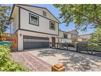 Charming two-story home showcasing a driveway and inviting front entrance with a well-manicured lawn at 1676 S Fairplay St, Aurora, CO 80012