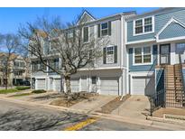 Exterior shot of a townhome featuring a one car garage and stairs leading to the front door at 1699 S Trenton St # 147, Denver, CO 80231