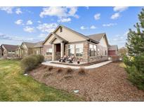 Charming single-story home featuring stone accents and a welcoming front porch with two chairs at 12564 Madison Way, Thornton, CO 80241
