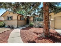 Charming home featuring a beautiful front yard with mature landscaping and a welcoming walkway at 985 S Jellison St, Lakewood, CO 80226