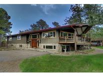 Charming, unique home showcasing a harmonious blend of stone and wood accents, complemented by a spacious driveway at 207 County Road 65, Evergreen, CO 80439