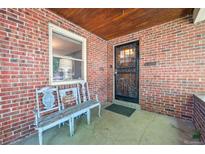 Inviting brick front porch with a bench and detailed front door at 3044 W 40Th Ave, Denver, CO 80211