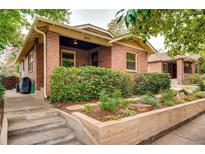Charming brick home featuring a well-maintained front yard with lush greenery and stone accents at 3044 W 40Th Ave, Denver, CO 80211
