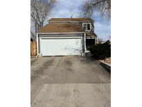 Charming home with two-car garage, gray siding, brown roof, and a large concrete driveway at 11449 E 1St Ave, Aurora, CO 80010