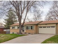 Charming single-story home with a well-maintained lawn, attached garage, and mature trees at 12286 W Tennessee Ave, Lakewood, CO 80228