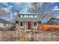 Charming home featuring a red front door, brick accents, and a quaint fenced front yard at 3176 S Acoma St, Englewood, CO 80110