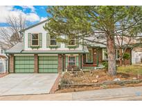 Charming two-story home with a two-car garage, green shutters, brick accents, and mature landscaping at 7681 S Jellison St, Littleton, CO 80127