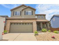Charming two-story home features a brick-accented garage and inviting front porch at 10540 Tracewood Cir, Highlands Ranch, CO 80130