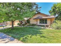 Charming single-story home with lush green lawn, mature tree, and classic architectural details at 4901 W 103Rd Cir, Westminster, CO 80031