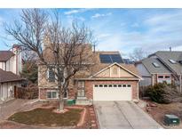 Charming two-story home features a brick-and-tan exterior, a two-car garage, and solar panels on the roof at 4334 Lisbon St, Denver, CO 80249