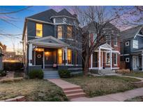 Charming two-story home with gray painted brick, manicured front yard, and inviting walkway at 713 S Washington St, Denver, CO 80209
