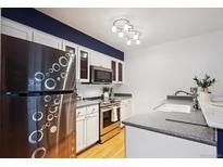 Modern kitchen features stainless steel appliances, white cabinetry, and sleek countertops at 14231 E Dickinson Dr # E, Aurora, CO 80014