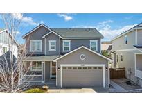 Charming gray two-story home featuring a covered porch and an attached two-car garage at 3323 Starry Night Loop, Castle Rock, CO 80109