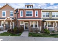 Charming two-story townhouse featuring a cozy front porch with stone accents and well-maintained landscaping at 22725 E Ottawa Pl, Aurora, CO 80016
