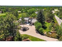 Stunning home with lush landscaping, circular brick driveway, and mature trees at 4 Greenridge Rd, Greenwood Village, CO 80111