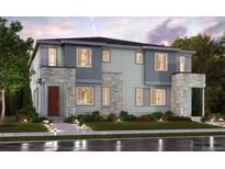 Beautiful modern home with stone accents, a red front door, and manicured landscaping at 14109 Deertrack Ln, Parker, CO 80134