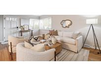 Bright living room featuring hardwood floors, stylish furnishings, and a large window for natural light at 3620 Fairfax St, Denver, CO 80207