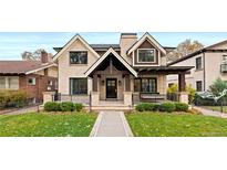 Beautiful two-story home boasting a manicured front yard, covered porch, and classic architectural details at 2218 S Clayton St, Denver, CO 80210
