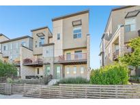 Modern townhome featuring a fenced yard, balcony, and contemporary architectural details at 5668 Galena St, Denver, CO 80238