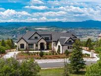 Breathtaking exterior view of a stunning estate with mountain views and lush landscaping at 860 Diamond Ridge Cir, Castle Rock, CO 80108