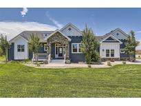 Charming home featuring a stone-accented entrance, well-manicured lawn, and blue and white color scheme at 41975 Muirfield Loop, Elizabeth, CO 80107