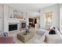 Bright living room featuring a fireplace, modern decor, and an open floor plan at 5895 S Taft Ct # H, Littleton, CO 80127