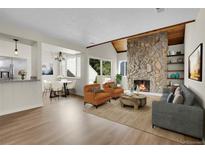 Inviting living room featuring a stone fireplace, wood ceiling, and an open layout to the dining area at 13619 E Yale Ave # C, Aurora, CO 80014