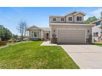 Charming two-story home with a well-manicured lawn and attached two-car garage at 21690 Longs Peak Ln, Parker, CO 80138
