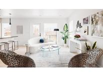 Bright living room features a modern white sofa, clear coffee table, and trendy leopard print chairs at 12555 W 10Th Ave, Golden, CO 80401