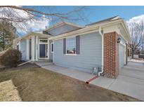 Charming single-Gathering home featuring blue siding, brick accents and a well-manicured lawn at 12638 James Pt, Broomfield, CO 80020