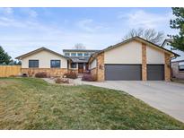 Charming single-Gathering home with well-maintained lawn, two-car garage, and inviting front entrance at 6151 W Evans Pl, Lakewood, CO 80227